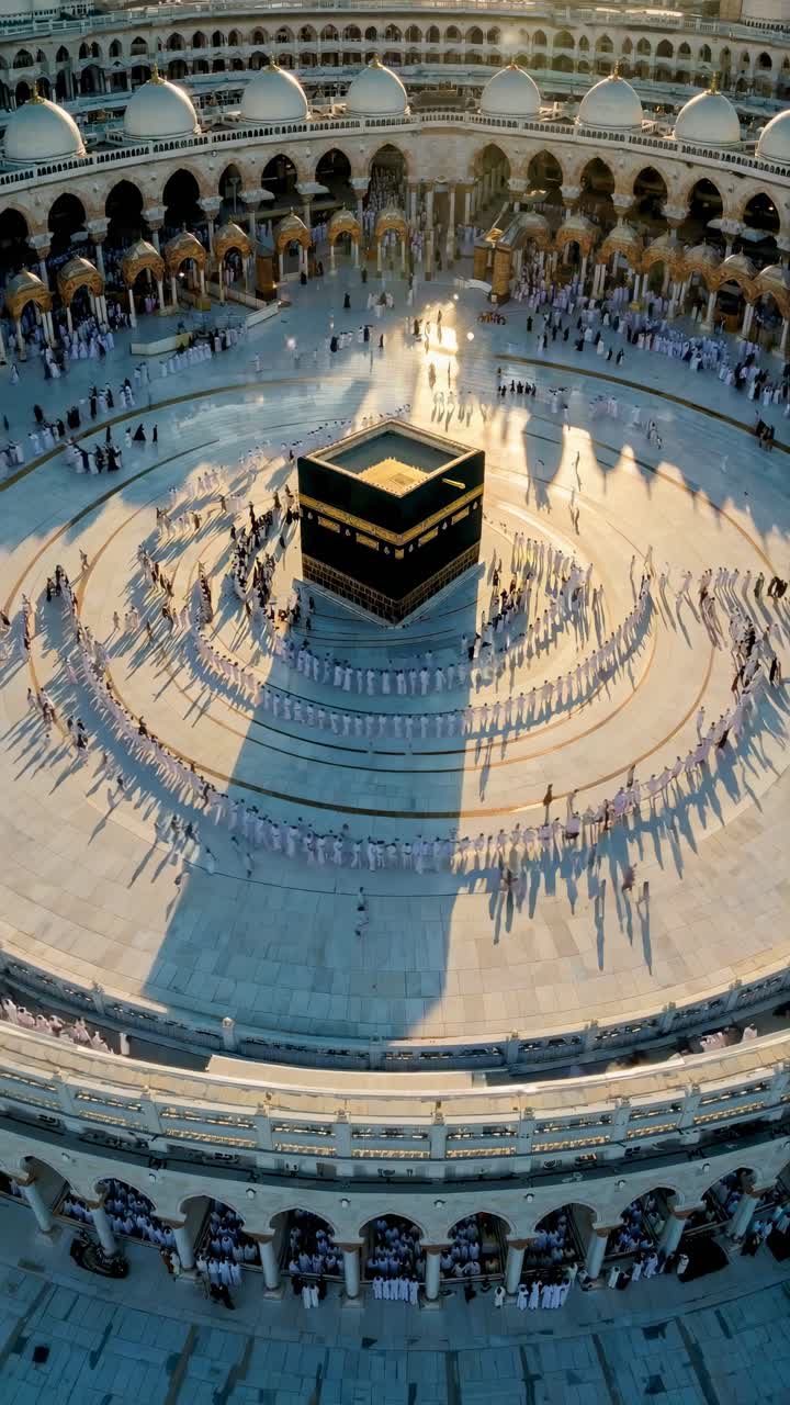 Aerial view of a large gathering around a central structure, capturing shadows and symmetry