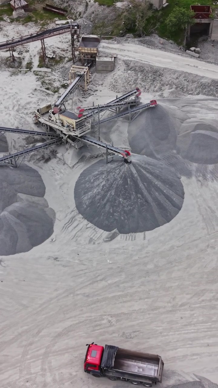 Large industrial machine moves materials at a gravel site during sunny day