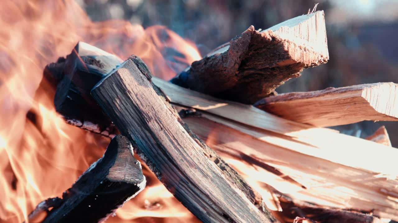 Meat skewers and traditional boerewors on grid turned during open fire barbecue