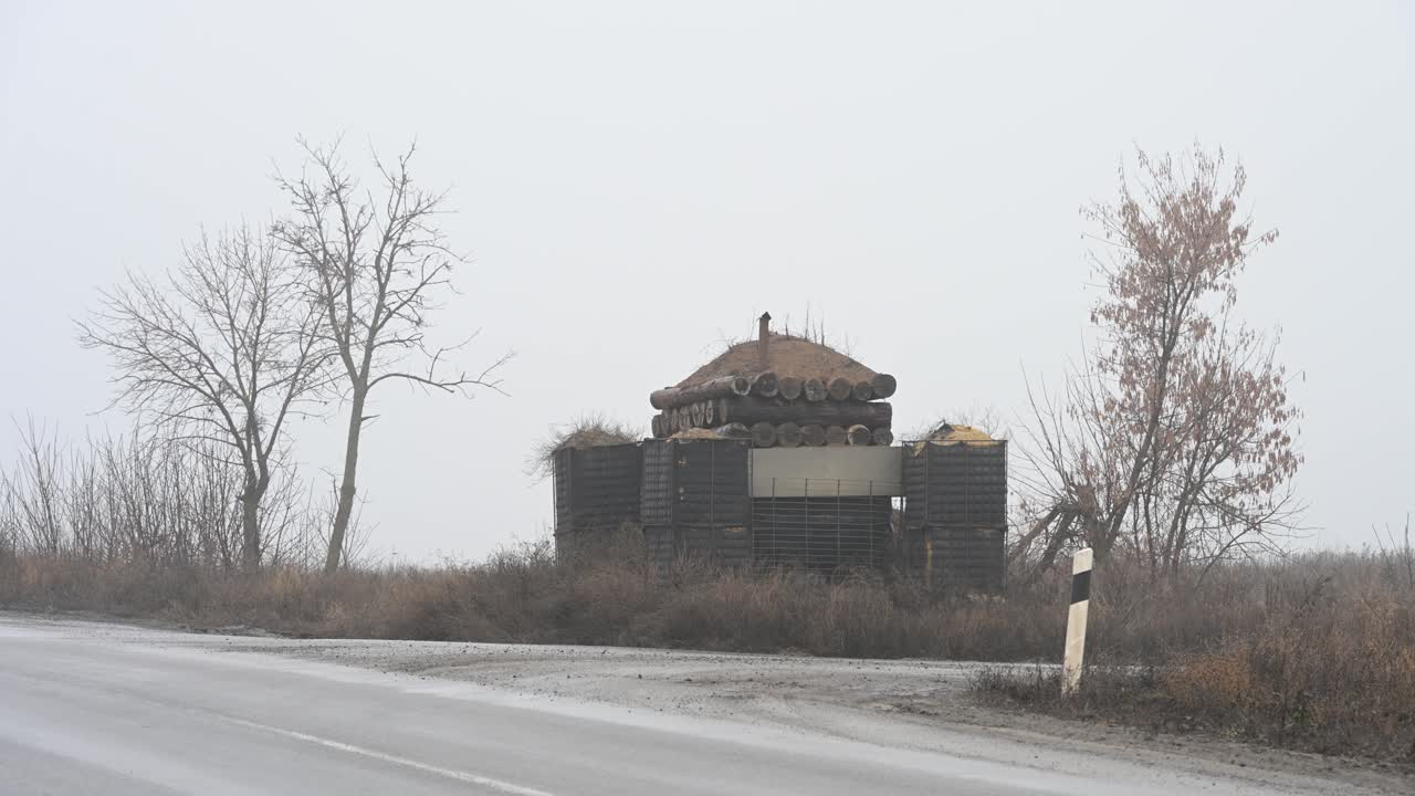 A makeshift military checkpoint made of tires and sandbags on the foggy outskirts of Kramatorsk, Ukraine. Fortifications like this are a common sight on roads near the Donbas frontline