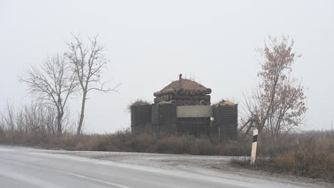 a makeshift military checkpoint made of tires and sandbags on the foggy outskirts of kramatorsk, ukraine. fortifications like this are a common sight on roads near the donbas frontline