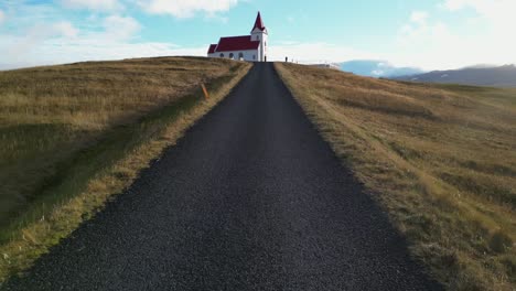 Drohnenaufnahme-Der-Straße,-Die-Im-Winter-Zur-Kirche-In-Island-Führt