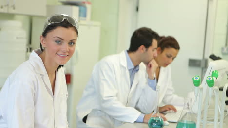 estudiantes de química trabajando en un experimento en el laboratorio