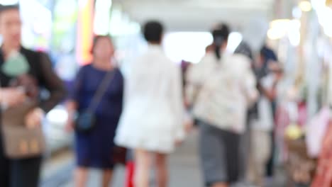 Blurred pedestrians strolling through lively outdoor park market area