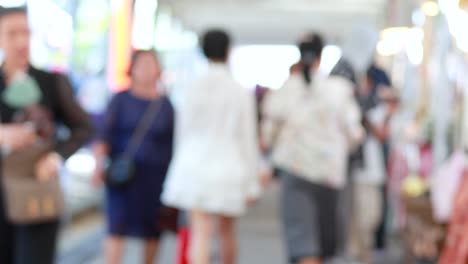 blurred pedestrians strolling through lively outdoor park market area