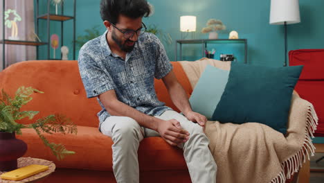 young indian man suffer from painful severe knee joint ache, leg muscles illness cramps rheumatism