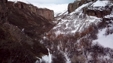 elevating above a rugged canyon and cliffs with snowy hiking trails below