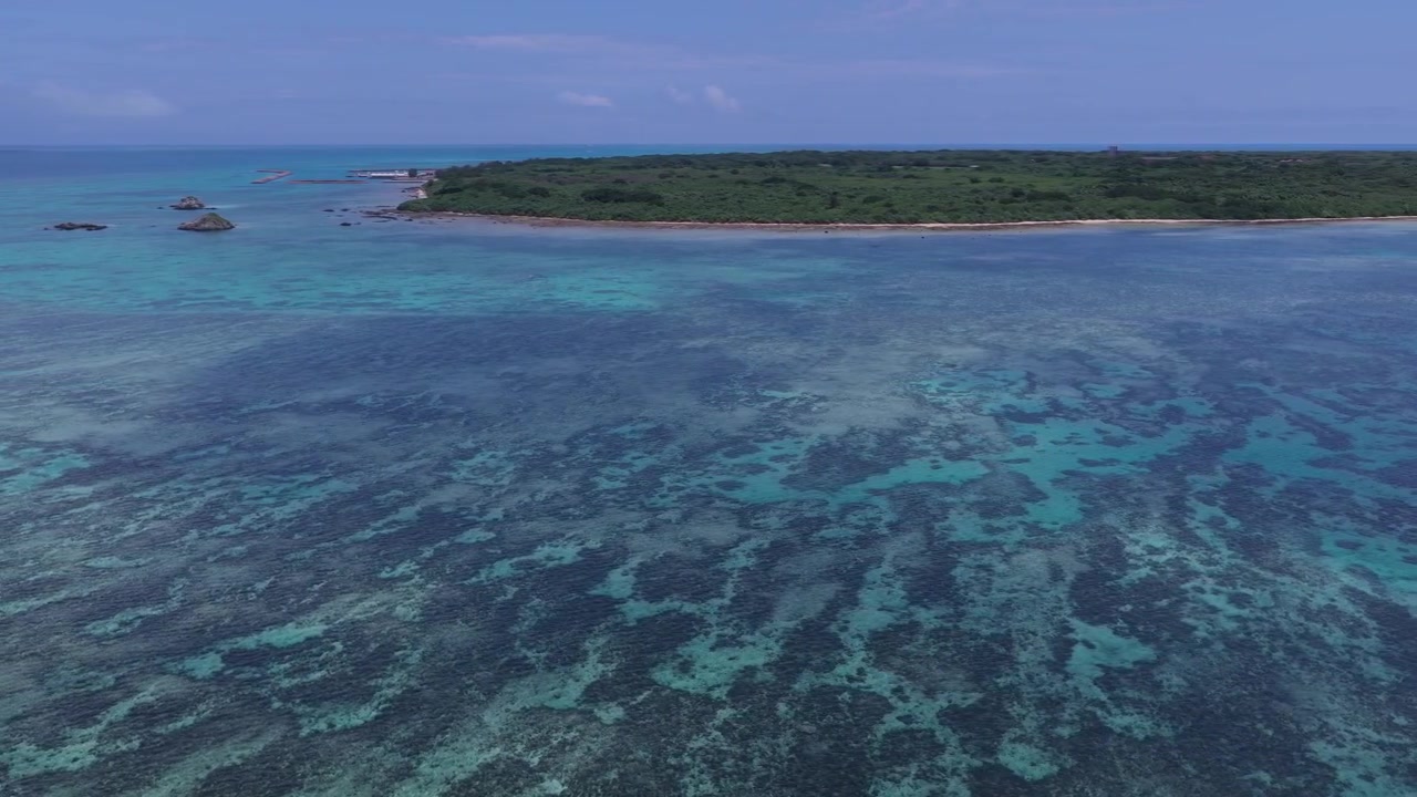 Carrellata orizzontale a sinistra sulle acque costiere turchesi e la barriera corallina vicino al molo Nishi e alla spiaggia Kondoi, isola di Taketomi, Okinawa, Giappone