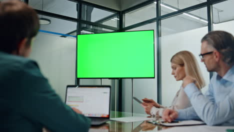 socios de negocios trabajando pantalla verde tv. personas de primer plano escuchando conferencia