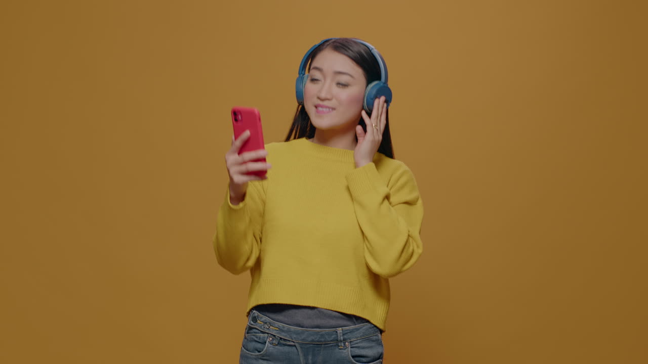 Positive adult listening to music and singing song on camera