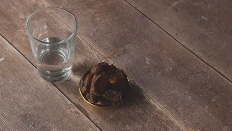 high angle shot of water and dates on wooden table