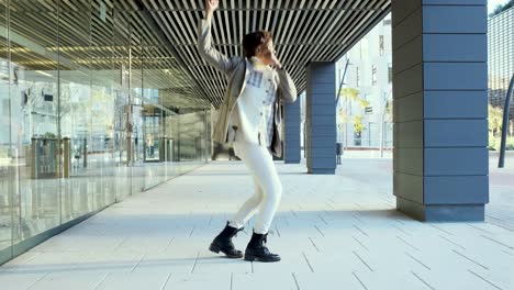 carefree and happy business woman dancing outdoors in the financial district.