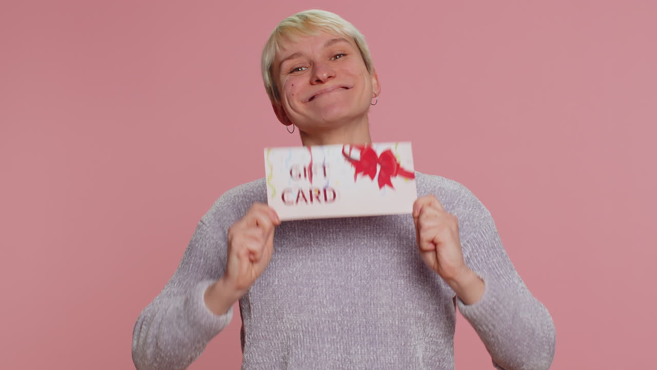 상점 휴일 판매를 위한 선물 할인 증서 쿠폰을 가리키는 젊은 여성