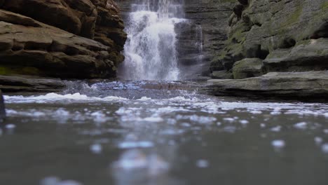 Low-angle-view-of-rocky-valley-waterfall-and-mountain-river