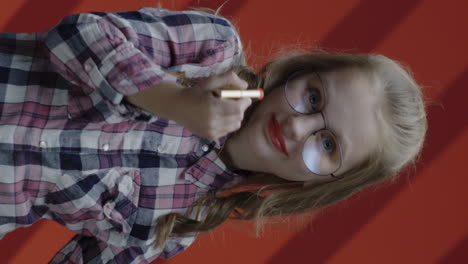 young girl applying lipstick