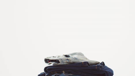 close up of folded jeans with different shades on white background with copy space