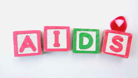 aids spelled out in blocks with red ribbon