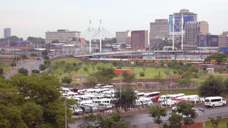 establishing shot of johannesburg south africa with nelson mandela bridge and passenger train foreground 1