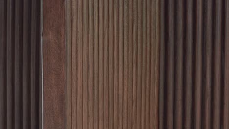 camera closes on modern ribbed texture of rich dark timber furniture