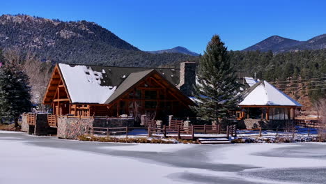 Frozen-ice-Evergreen-Lake-House-aerial-cinematic-drone-hockey-player-ice-skater-dream-fresh-first-snow-freezing-ice-winter-cold-bluebird-sunny-noon-downtown-golf-course-circle-to-the-right-movement