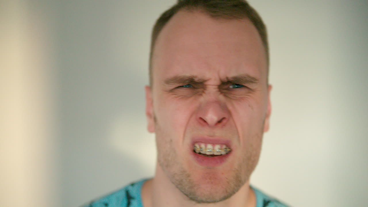 мужчина бьет себя рукой по лицу в замедленной съемке