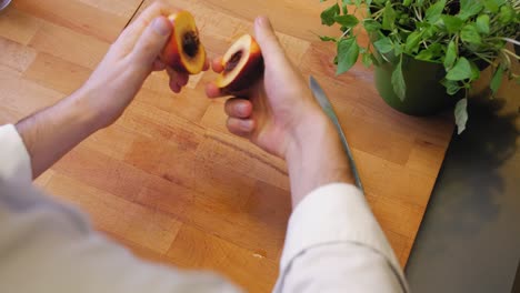 the cook cuts the nectarine on a wooden board