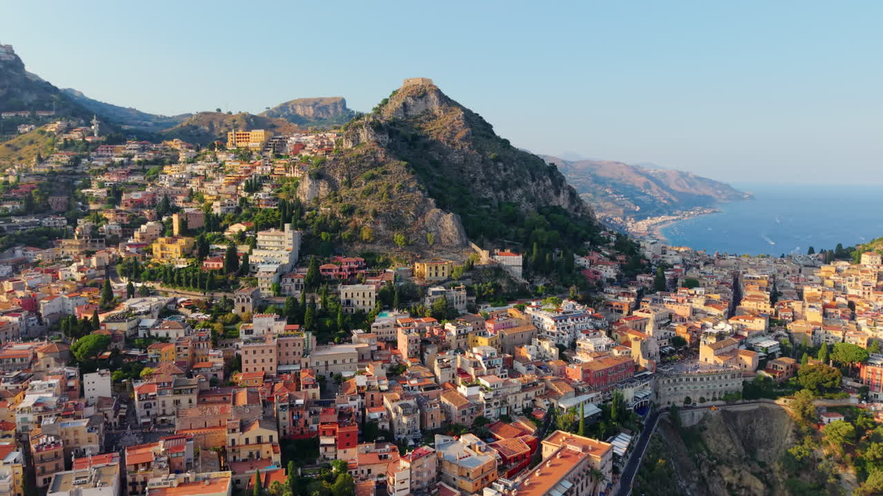 Colorful houses in Taormina hilltop town in Sicily at sunset. Aerial