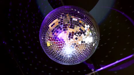 Mirror-disco-ball-hanging-from-the-ceiling-is-rotating