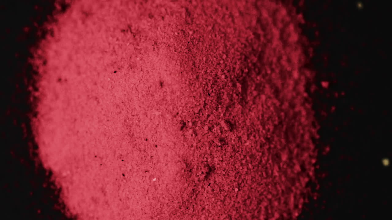 Video of close up of red powder with copy space on black background