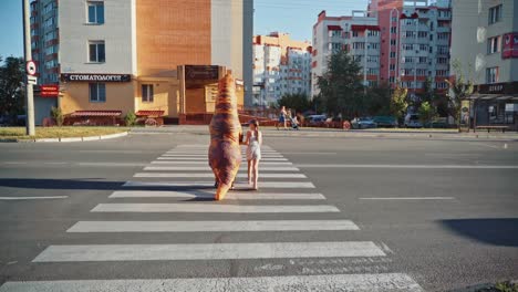 girl walking with dinosaur. animator in dinosaur costume walking with girl friend