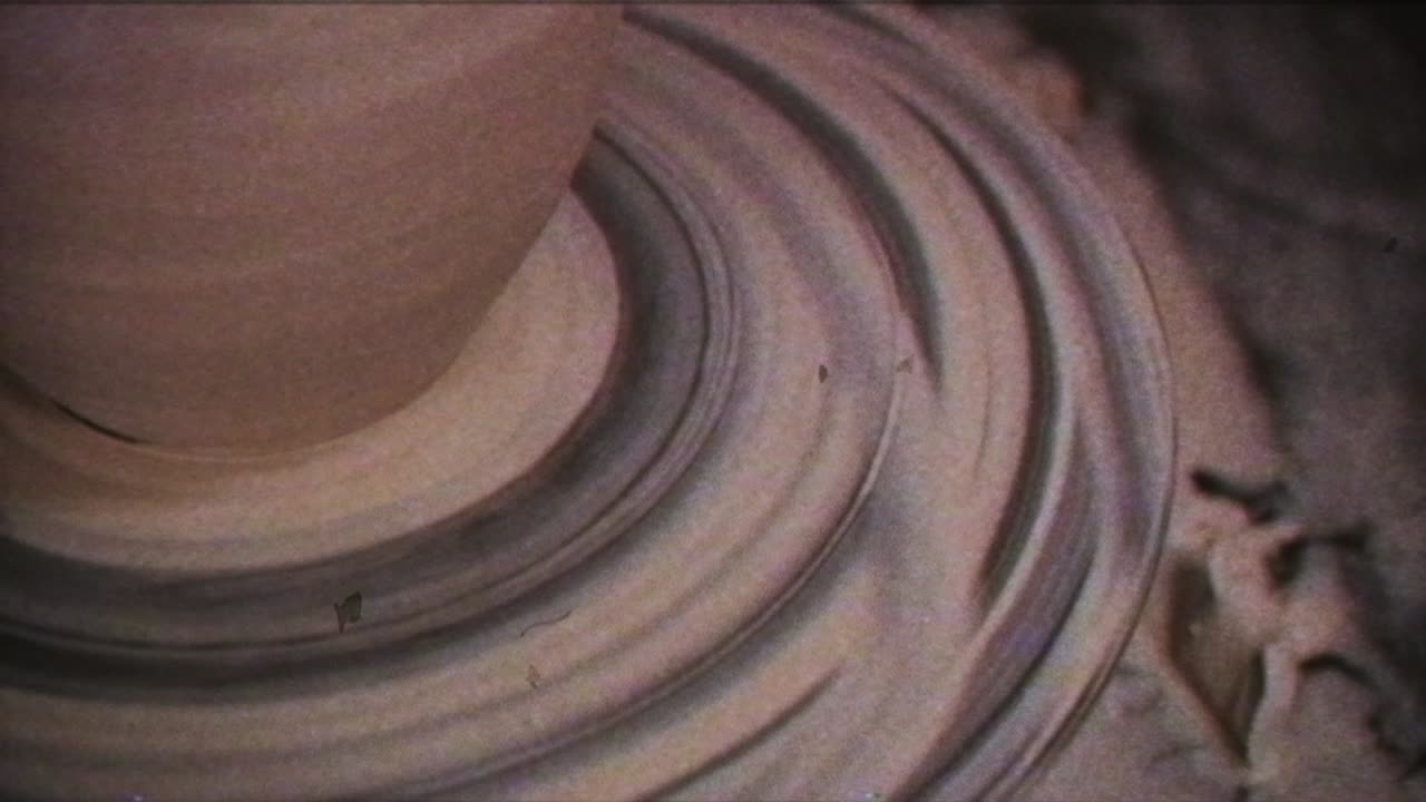 The potter makes a jug of clay. Vintage effect. A man makes a vase on a potter's wheel