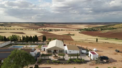 aerial dolly above rural farm house estate surrounded by the plains in extremadura, spain, showcasing the vast, open landscape and fields