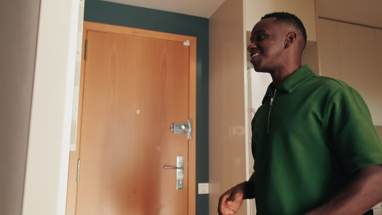 Young African Man Yawning and Adjusting Hair in Mirror at Home
