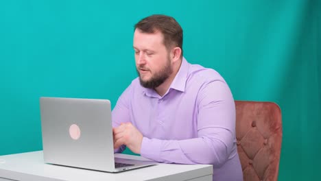 un joven empresario feliz tiene una reunión de conferencia en una computadora portátil en una pantalla verde. retrato de un hombre hablando mirando a su computadora portable. hombre trabajando en su escritorio en la oficina