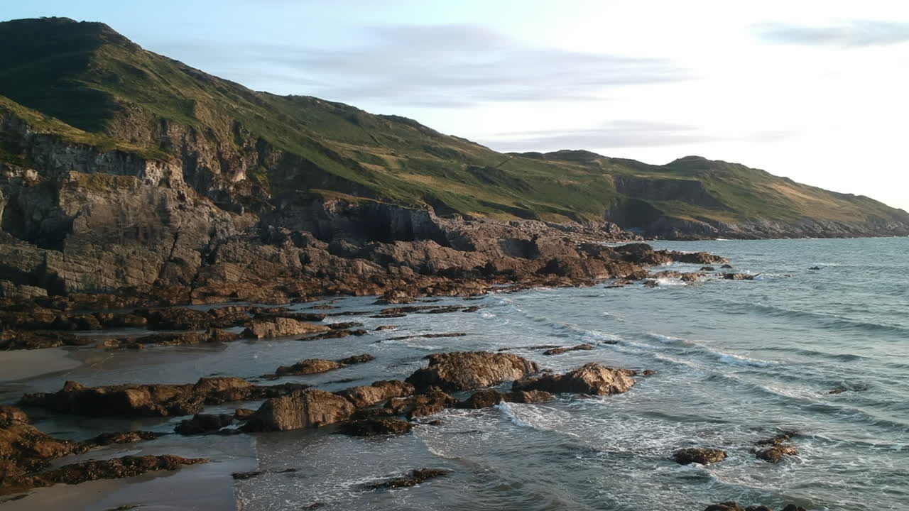 Serene Coastal Landscape with Rocky Shore and Green Hills