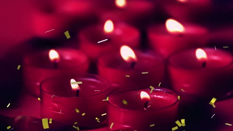 Animation-of-gold-confetti-falling-over-lit-red-candles-on-black-background