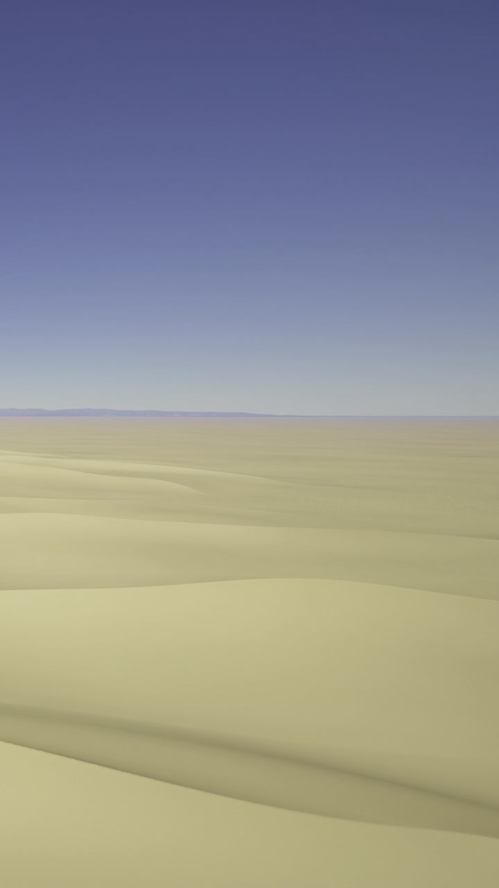 Waves of golden sand stretch endlessly under a brilliant blue sky