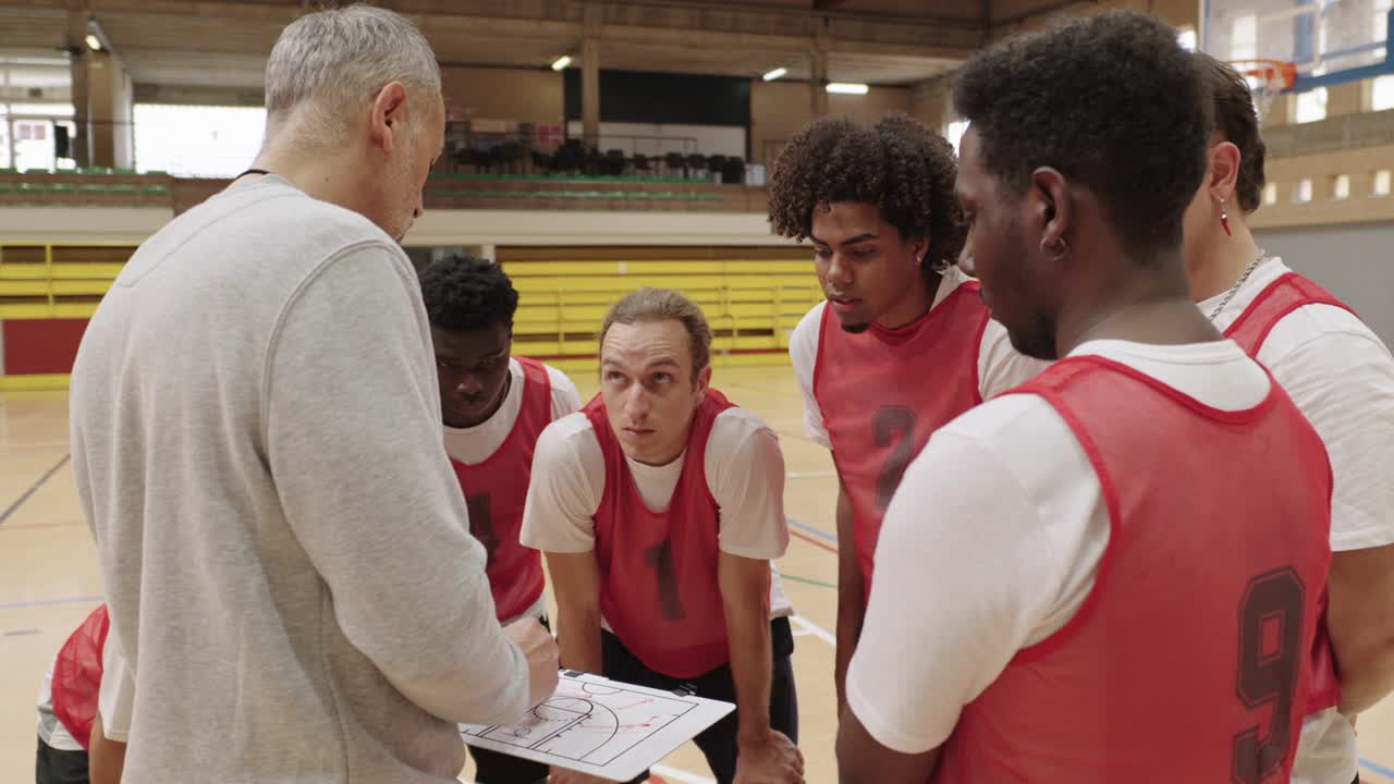Basketballtrainer bespricht Strategie mit seinem Team