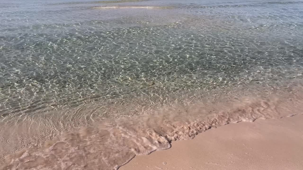 Gentle waves and transparent water at Cala Ses Covetes Mallorca Spain