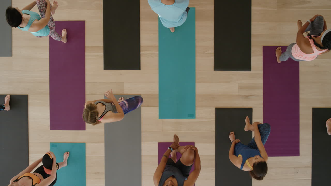 vista superior de la clase de yoga de jóvenes sanos practicando posturas de estiramiento disfrutando del estilo de vida físico haciendo ejercicio en el estudio.