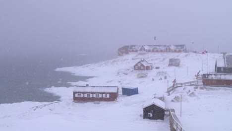 slow motion video of red houses on the arctic coast in a snowstorm in ilulissat, greenland