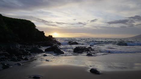 lowering slow motion scene of a rocky beach at sunset in maui hawaii