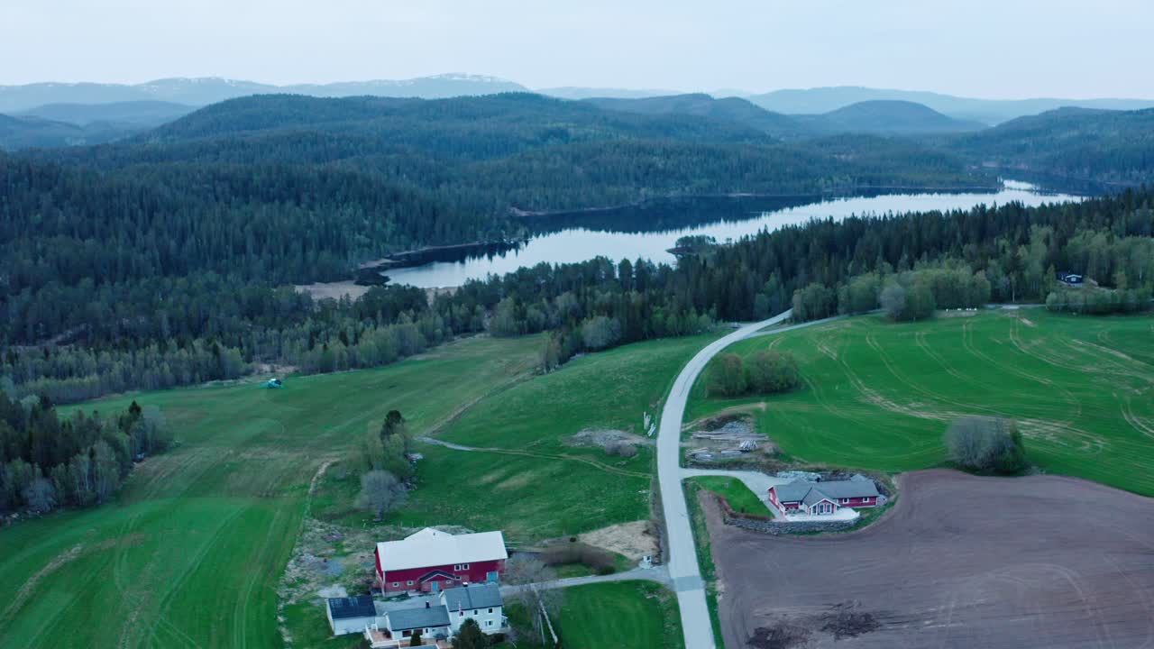 cabañas y camino que conduce al lago y al denso bosque en indre fosen, trondelag, noruega