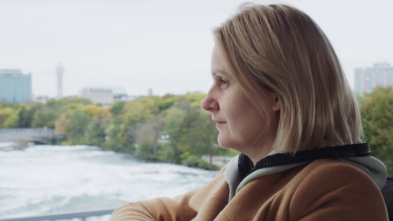 женщина едет по мосту через реку ниагара недалеко от ниагарских водопадов.