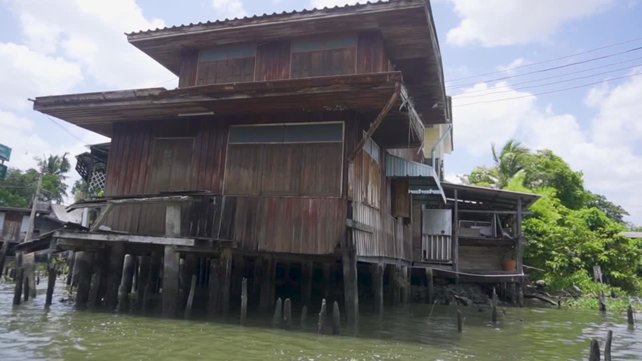 Handheld shot of wooden traditional house next to Chao Phraya River in Bangkok, Thailand