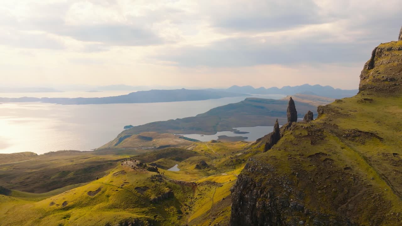 Aerial drone footage of the dramatic mountain landscapes and Old man of Storr on the Isle of Skye, Scotland. Sweeping panoramic views of majestic peaks, green valleys, and wild nature