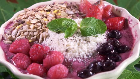 delicious smoothie bowl in a white bowl filled with raspberries and grains