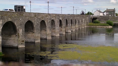 puente histórico sobre un río ancho en el campo de irlanda