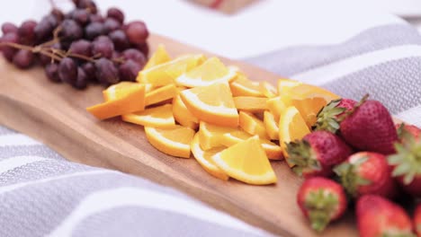 sliced fruit on wooden platter on a outdoor blanket 1080p 60fps