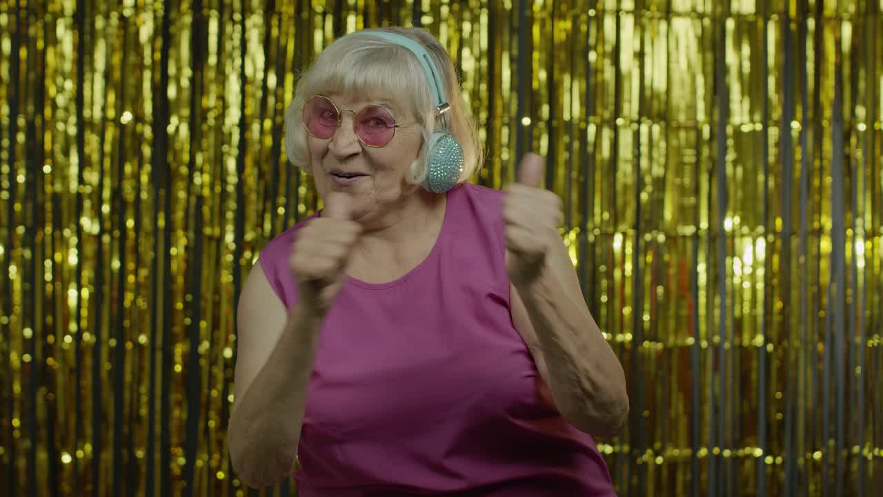 Anziana signora balla, ascolta musica in cuffia. Si rilassa, si diverte, sorride.